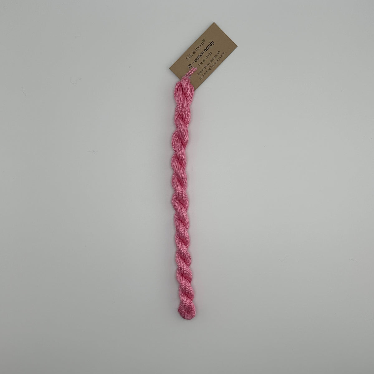 30 yard skein of silk & Ivory in the color 72 Cotton Candy with brown tag laying flat on white background