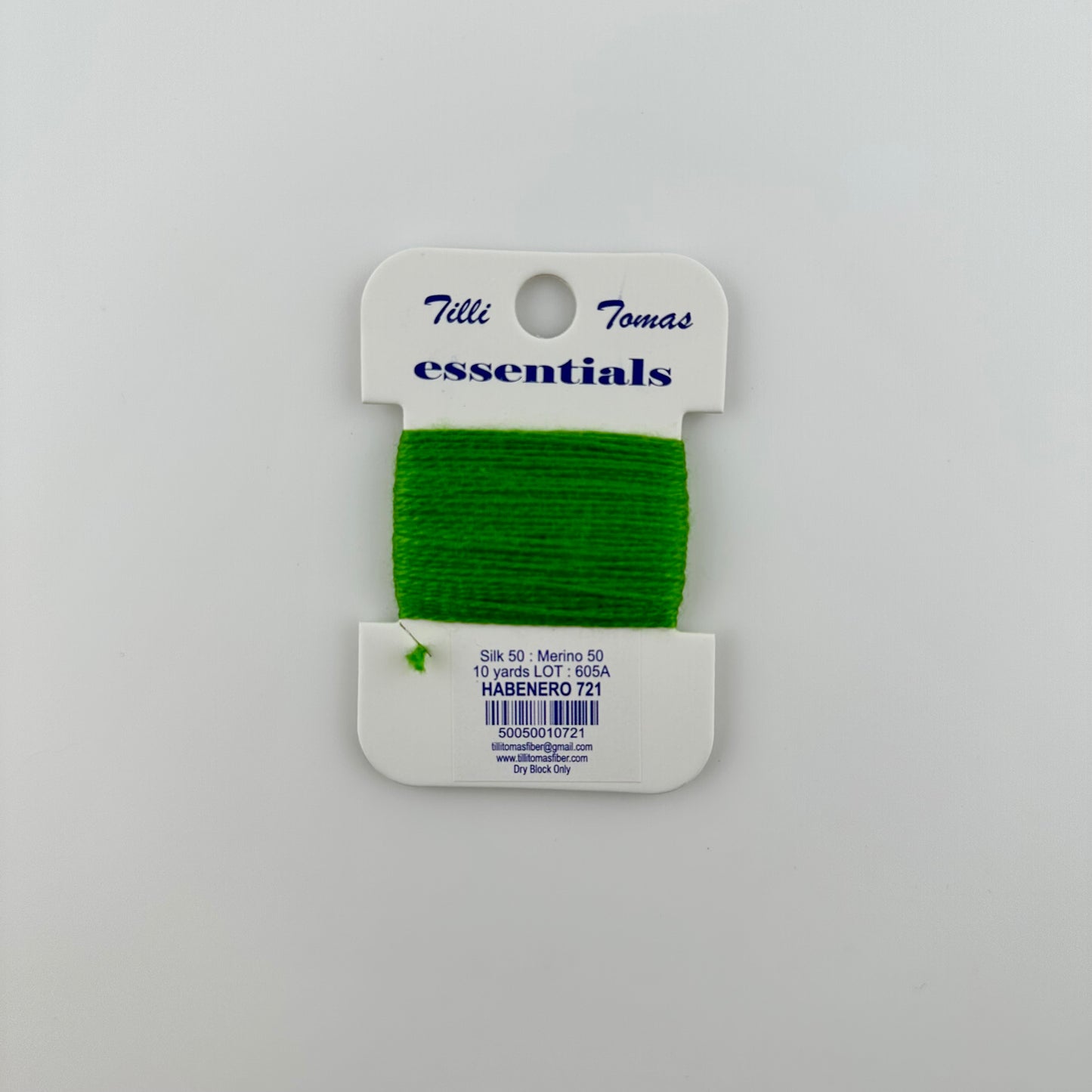 Tilli Tomas Essentials needlepoint thread, in a green habenero 721. 50% silk, 50% merino wool, 10 yards wound on a white cardboard card.