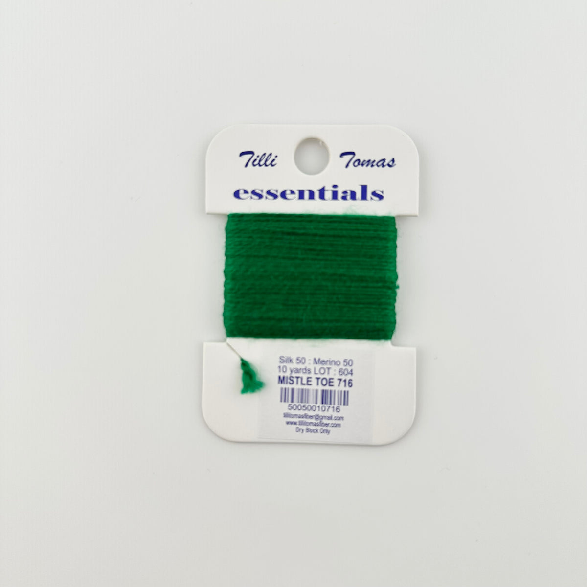 Tilli Tomas Essentials needlepoint thread, in green mistletoe 716. 50% silk, 50% merino wool, 10 yards wound on a white cardboard card.