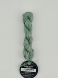 14 yard skein Planet Earth Silk 4 Ply needlepoint thread, in algae v1313 green, with round black and white label lying flat on white background.