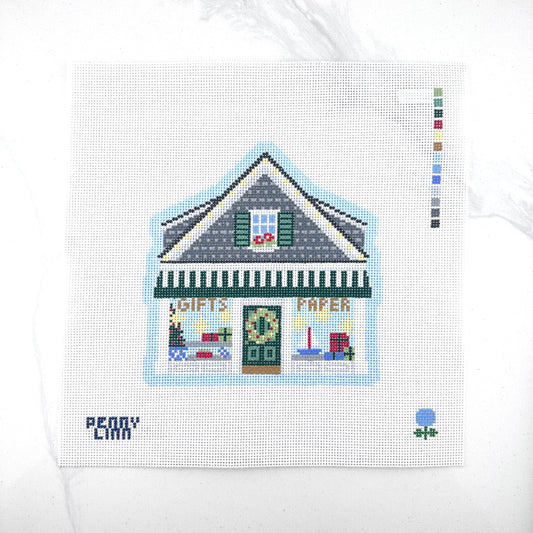 13 mesh needlepoint canvas featuring a Christmas stationery gift shop design, with a color swatch strip on the right and the brand name 'PENNY LINN' in the bottom left corner, displayed on a white marble surface.