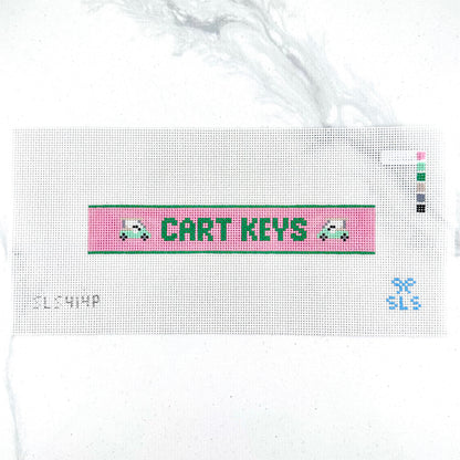 A needlepoint key fob canvas featuring a pink and green sign with the text 'CART KEYS' in green on 14 mesh lying flat on white background.