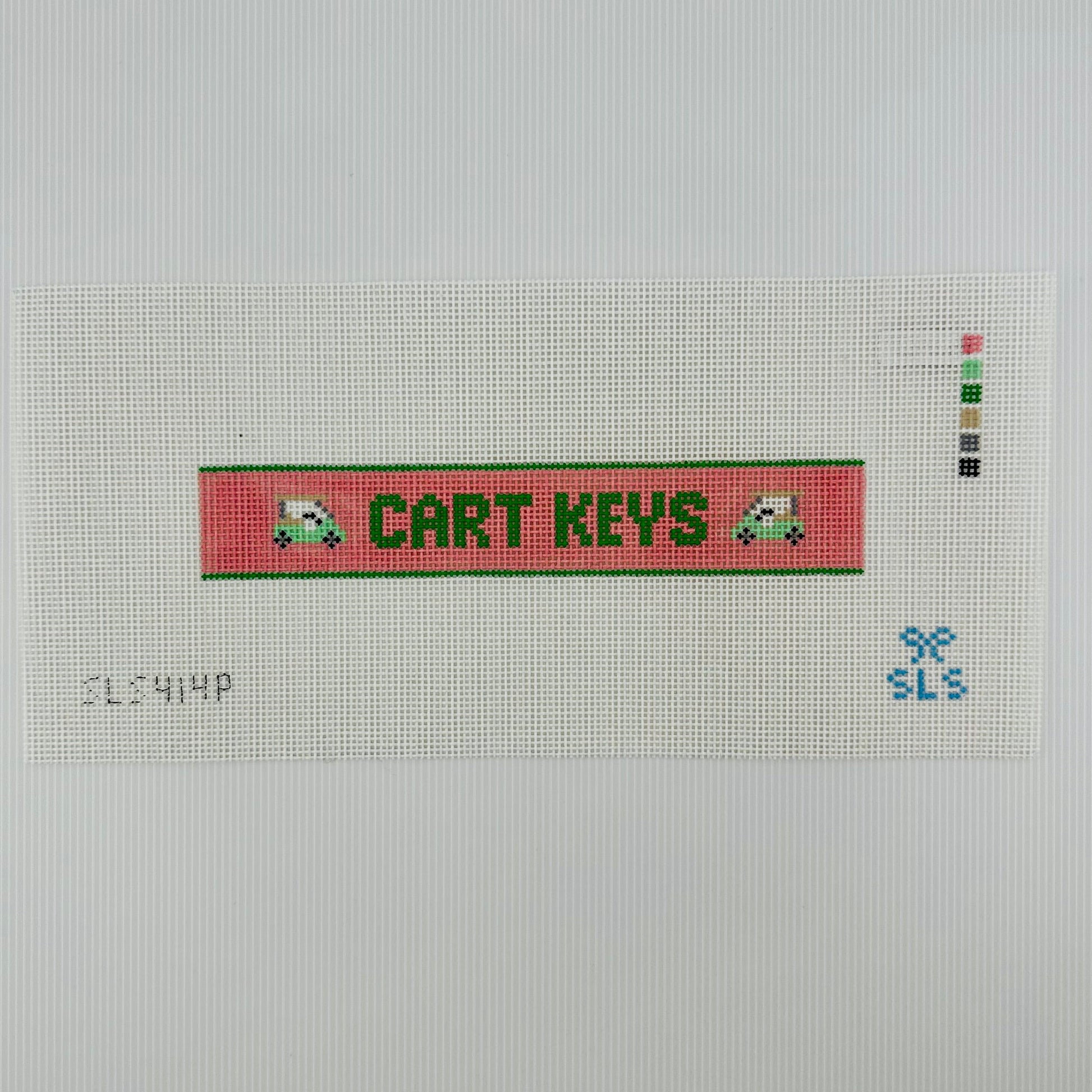 A needlepoint key fob canvas featuring a pink and green sign with the text 'CART KEYS' in green on 14 mesh lying flat on white background.