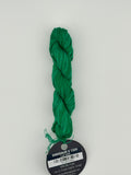 14 yard skein Planet Earth Silk 4 Ply needlepoint thread, in dinosaur v 1334  green with round black and white label lying flat on white background.