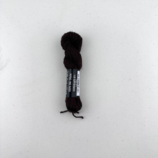 30 yard skein of Pepper Pot Silk needlepoint thread in a chocolate 071, with black and white label lying flat on white background