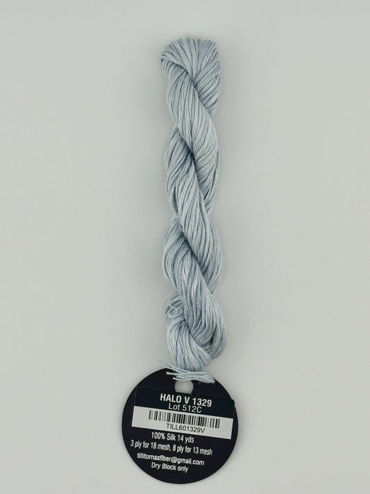 14 yard skein Planet Earth Silk 4 Ply needlepoint thread, in halo v 1329, light blue, with round black and white label lying flat on white background.