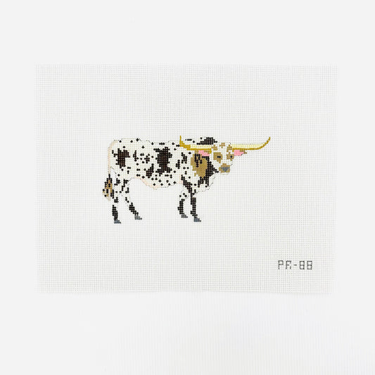 A needlepoint canvas featuring a brown and white spotted longhorn bull, displayed flat on a white background.