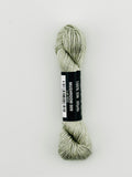 30 yard skein of Pepper Pot Silk needlepoint thread in mushroom 009, with black and white label lying flat on white background