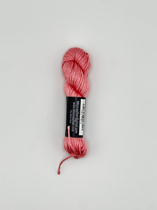 30 yard skein of Pepper Pot Silk needlepoint thread in strawberry frappe pink 014 with black and white label lying flat on white background