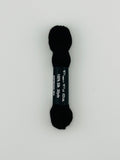 30 yard skein of Pepper Pot Silk needlepoint thread in espresso 064, with black and white label lying flat on white background