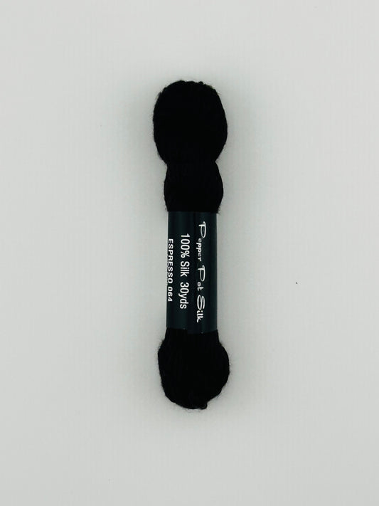30 yard skein of Pepper Pot Silk needlepoint thread in espresso 064, with black and white label lying flat on white background