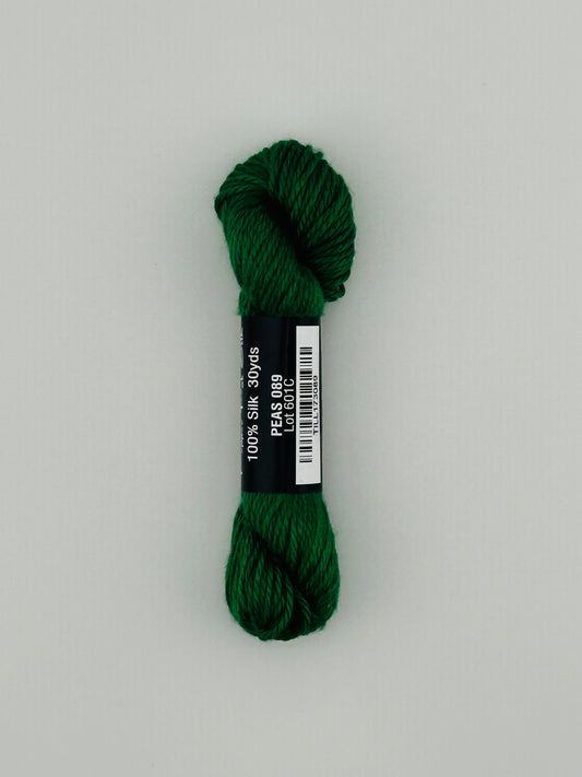 30 yard skein of Pepper Pot Silk needlepoint thread in peas 089, with black and white label lying flat on white background