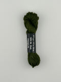 30 yard skein of Pepper Pot Silk needlepoint thread in Avocado 096 green, with black and white label lying flat on white background