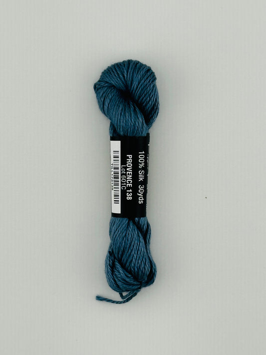 30 yard skein of Pepper Pot Silk needlepoint thread in provence 138, with black and white label lying flat on white background