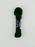 30 yard skein of Pepper Pot Silk needlepoint thread in spinach 149, with black and white label lying flat on white background