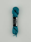 30 yard skein of Pepper Pot Silk needlepoint thread in fountain 168, with black and white label lying flat on white background