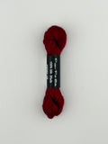30 yard skein of Pepper Pot Silk needlepoint thread in cherry 199, with black and white label lying flat on white background