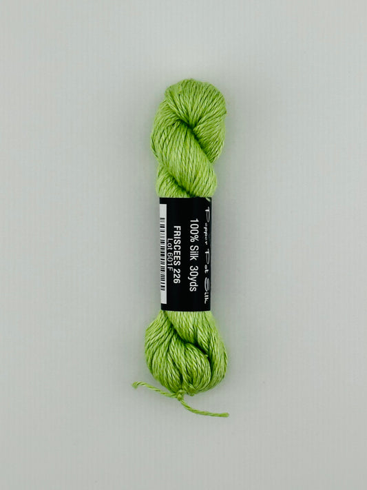 30 yard skein of Pepper Pot Silk needlepoint thread in friscees 226, with black and white label lying flat on white background