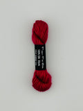 30 yard skein of Pepper Pot Silk needlepoint thread in tout sweet 243, with black and white label lying flat on white background
