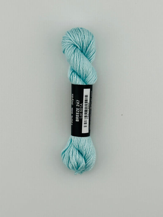 30 yard skein of Pepper Pot Silk needlepoint thread in breeze 247, with black and white label lying flat on white background