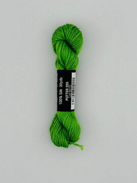 30 yard skein of Pepper Pot Silk needlepoint thread in putter 255, with black and white label lying flat on white background