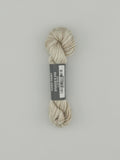 30 yard skein of Pepper Pot Silk  variegated needlepoint thread in stucco v310 with black and white label lying flat on white background