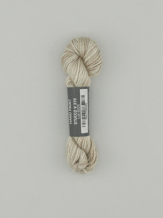 30 yard skein of Pepper Pot Silk  variegated needlepoint thread in stucco v310 with black and white label lying flat on white background