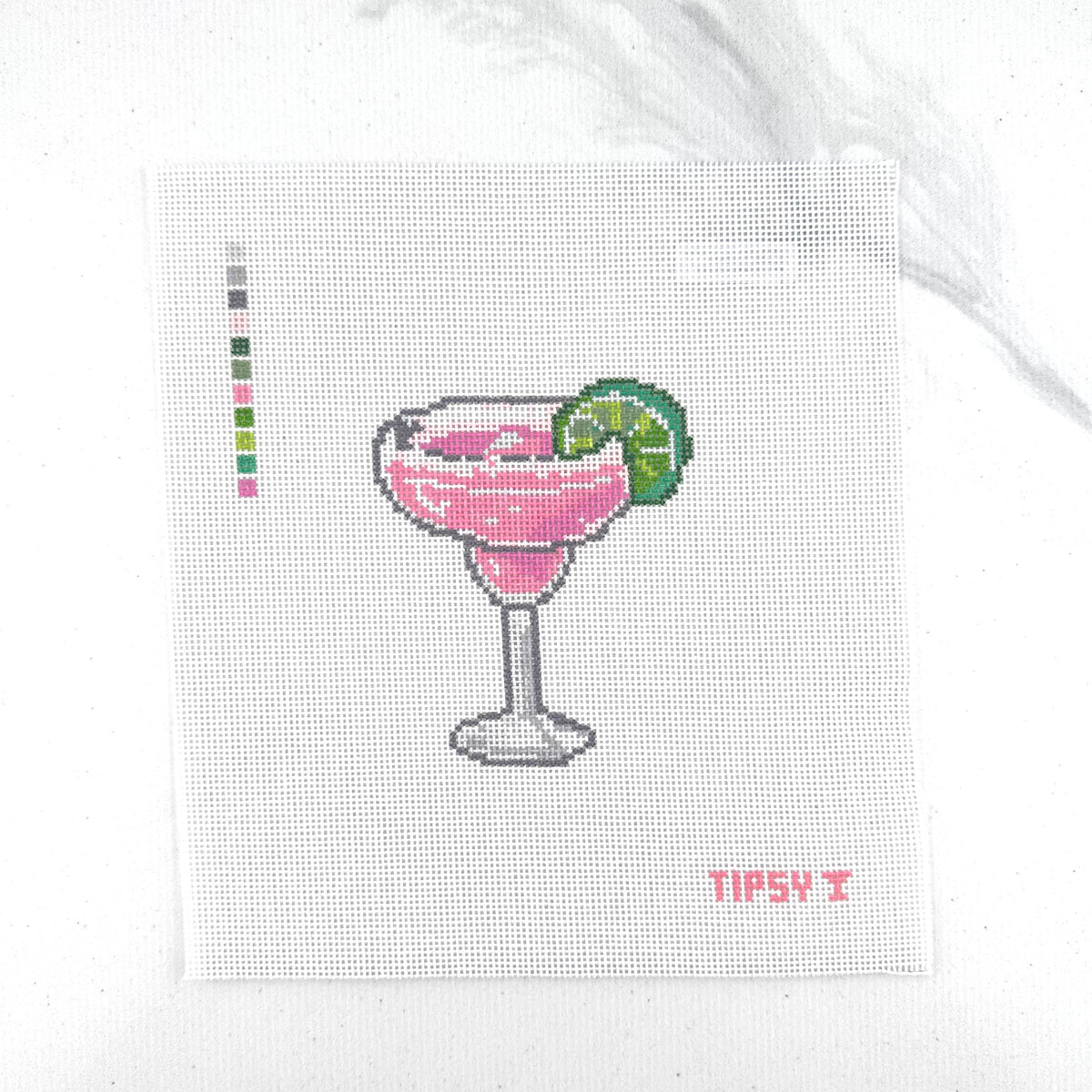 A square 18 mesh needlepoint canvas featuring a pink margarita cocktail in a glass with a lime wedge, on a white background with a small red TIPSY  text at the bottom right.