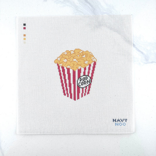 18 mesh needlepoint canvas featuring a red-and-white striped popcorn bucket filled with yellow popcorn, plus a small 'POP CORN' label. The canvas is photographed on a white surface, with the brand name 'NAVY NOO' printed in the bottom right corner.