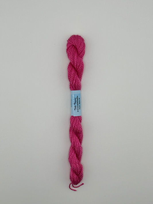 30 yard skein of essentials needlepoint thread in Ribbon S844 pink, with blue label lying flat on white background.