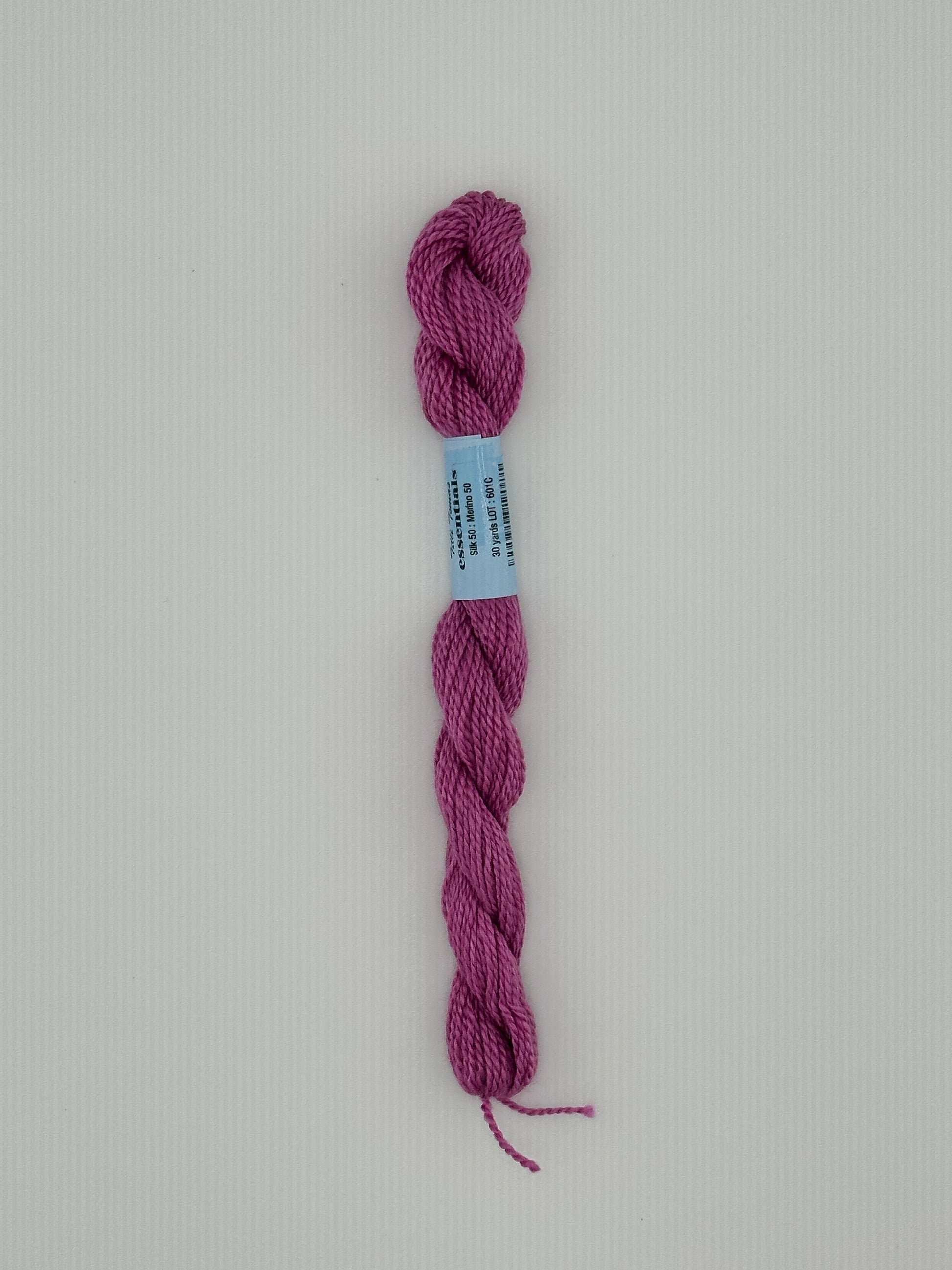 30 yard skein of essentials needlepoint thread in Rocket S7, with blue label lying flat on white background6 pink