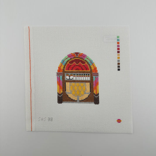A needlepoint canvas featuring a vintage jukebox design by saturnalia stitching lying flat against a plain white background.