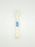 30 yard skein of essentials needlepoint thread in white 502, with blue label lying flat on white background