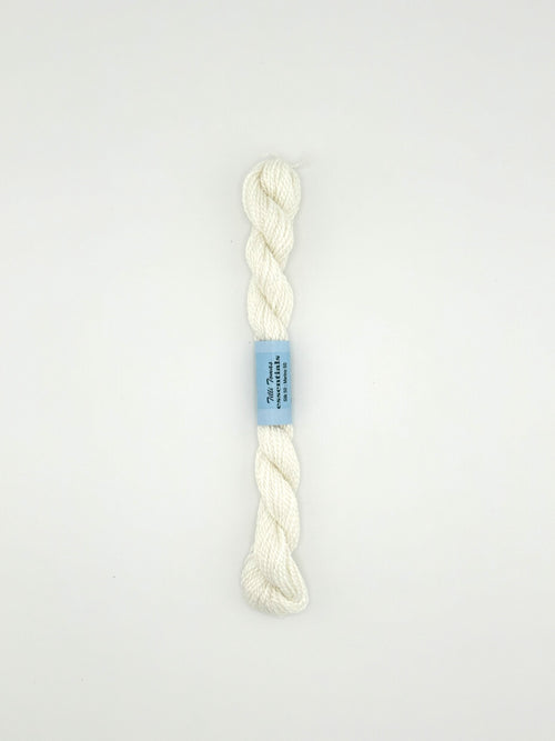 30 yard skein of essentials needlepoint thread in white 502, with blue label lying flat on white background