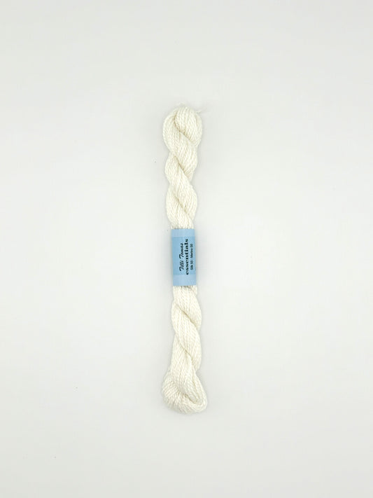 30 yard skein of essentials needlepoint thread in white 502, with blue label lying flat on white background