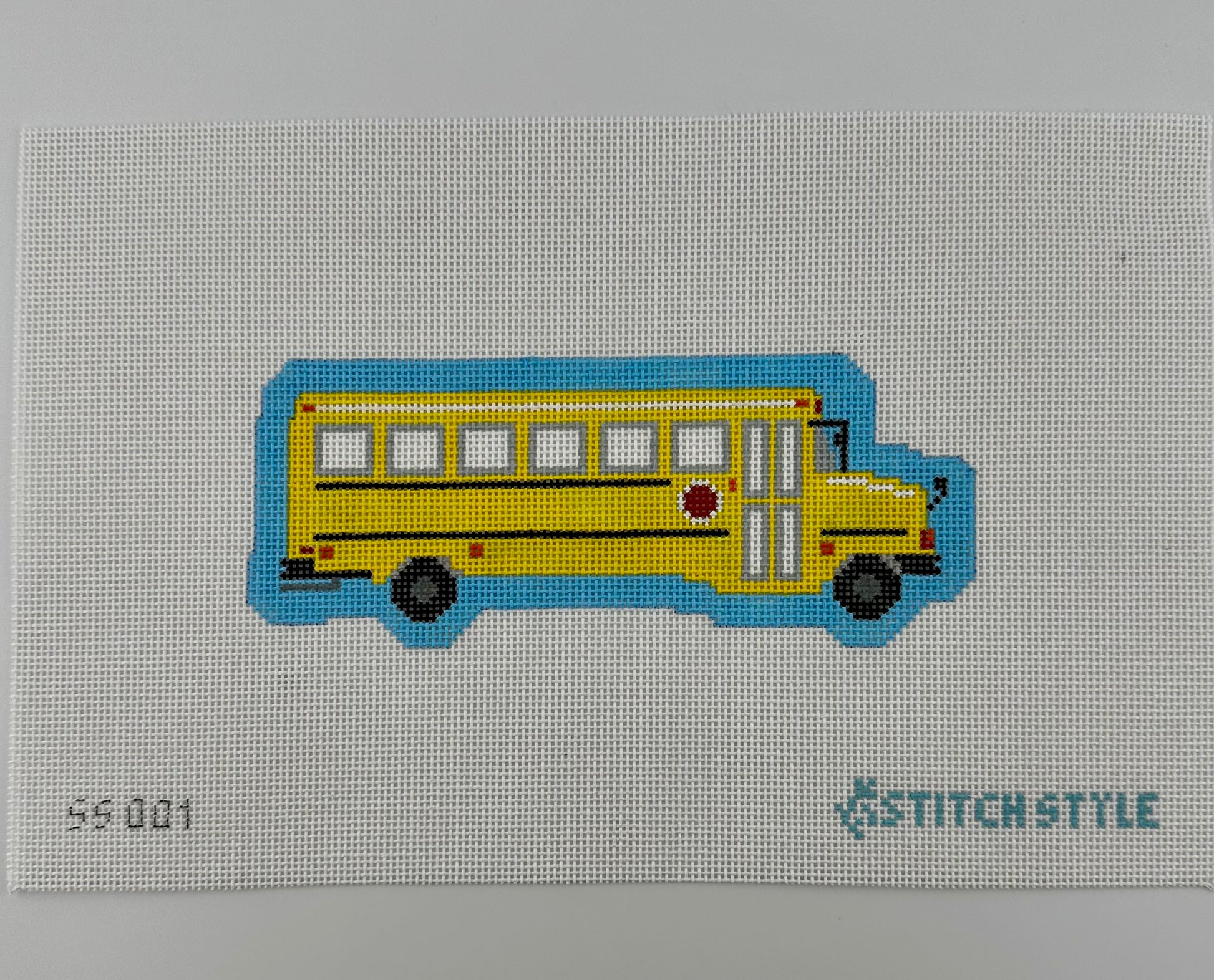A 18 mesh needlepoint canvas featuring a yellow school bus with black wheels and a blue shadow, on a white background with the Stitchstyle logo in the bottom right corner.