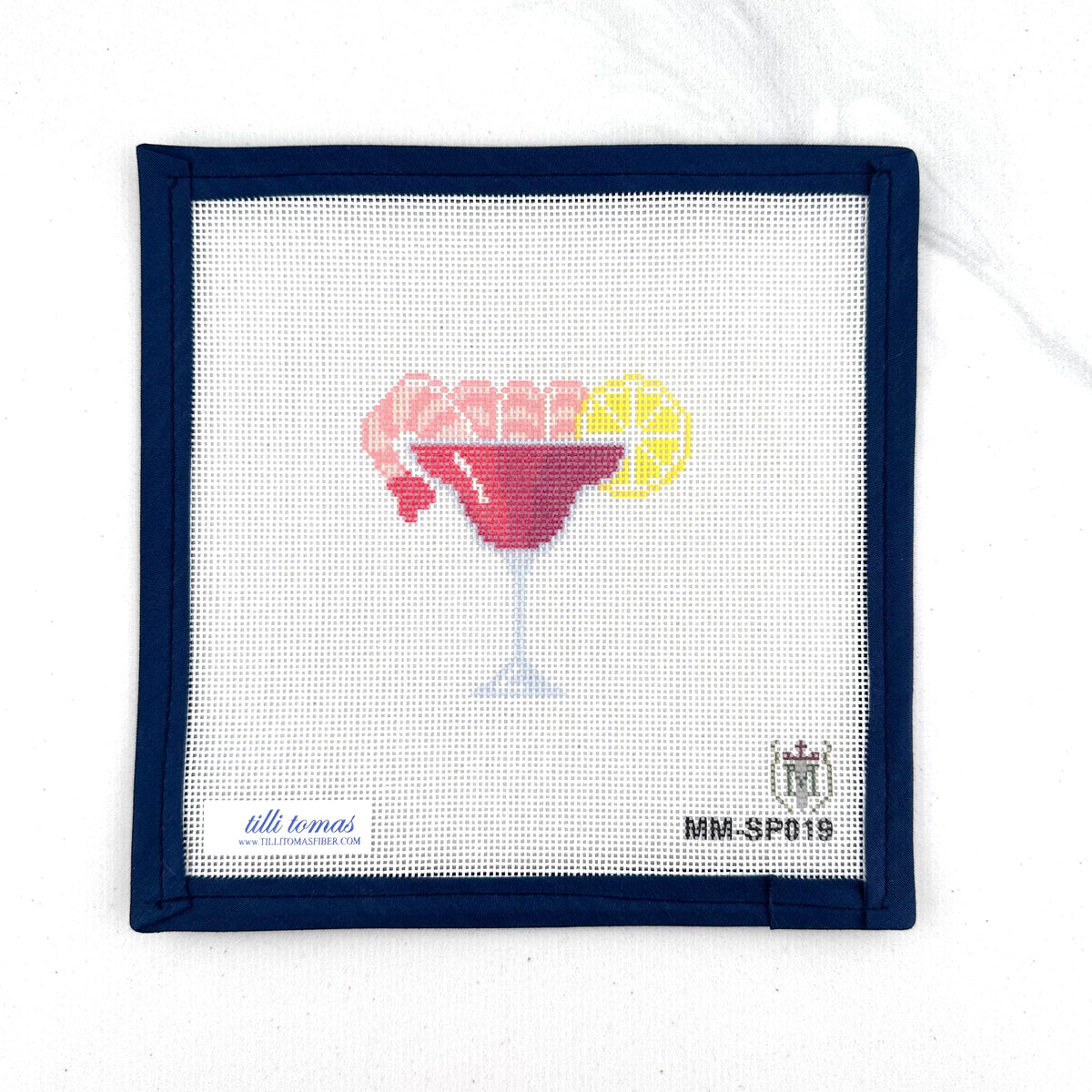 shrimp cocktail glass with a lemon wedge on 18 mesh needlepoint canvas laying flat on white background.