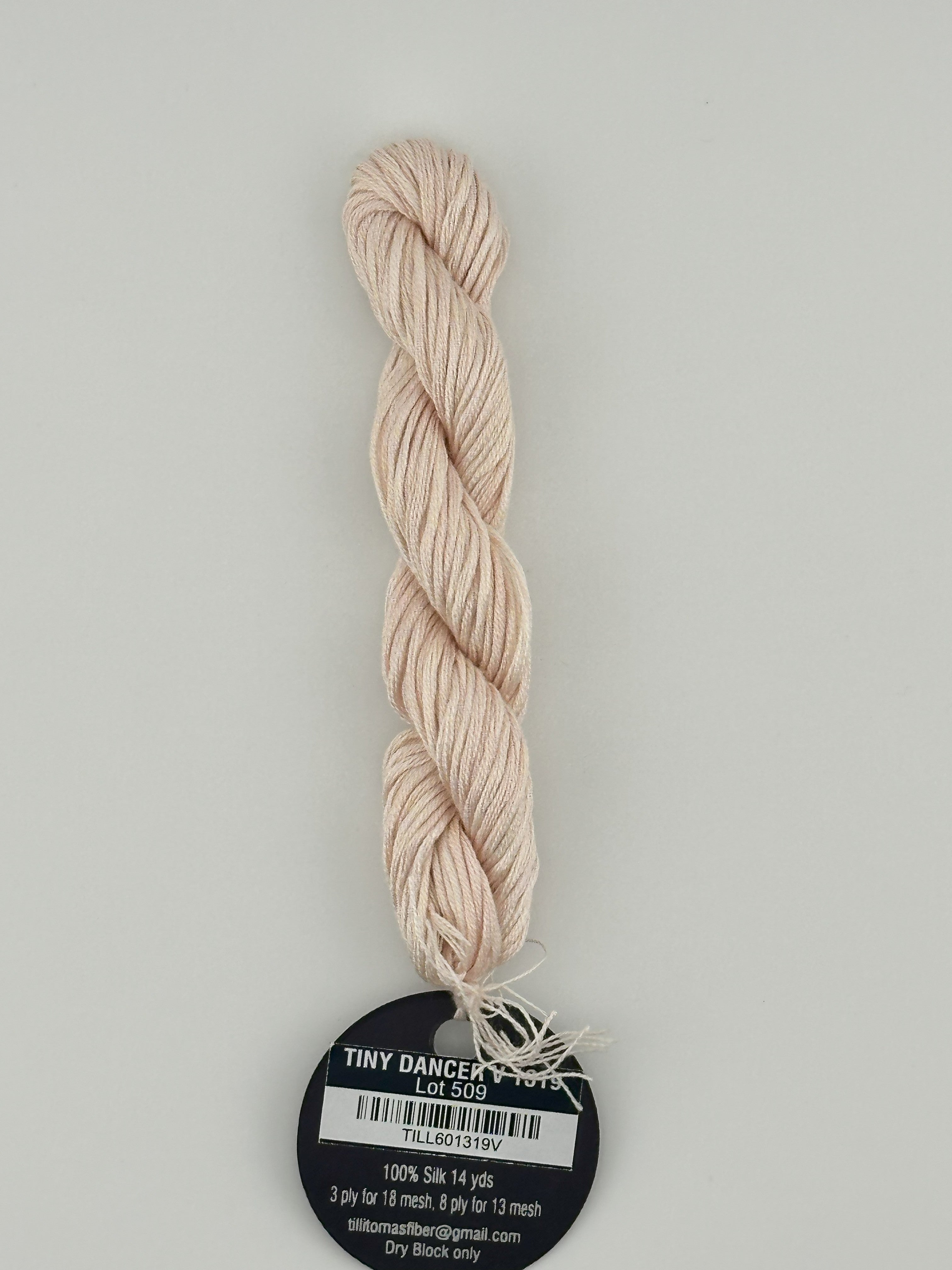 14 yard skein Planet Earth Silk 4 Ply needlepoint thread, in tiny dancer v 1319, with round black and white label lying flat on white background.