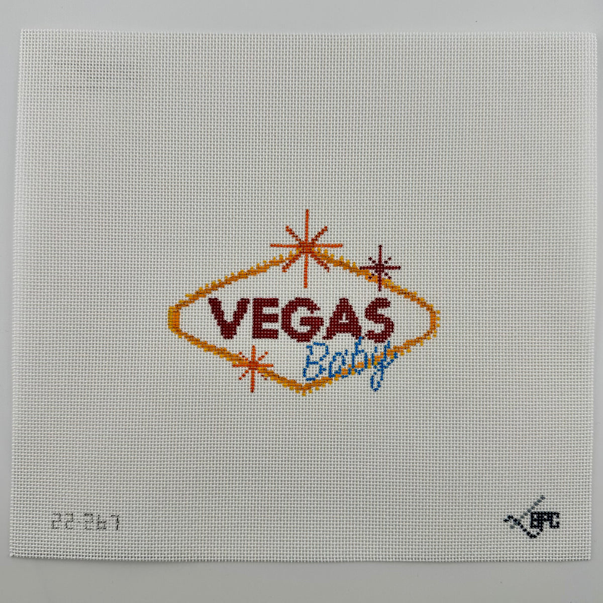 18 mesh needlepoint canvas featuring a 'Vegas Baby' design. The design includes a gold diamond outline, dark red 'VEGAS' text, and blue 'Baby' script, accented with small orange and red starbursts.