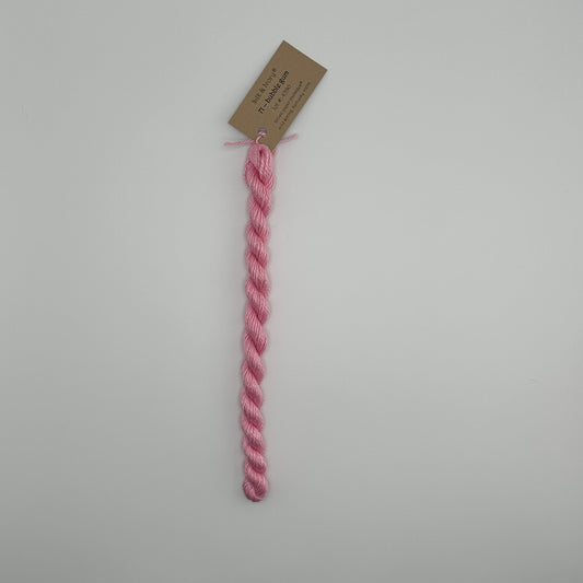 30 yard skein of silk & Ivory in the color 71 Bubblegum with brown tag laying flat on white background