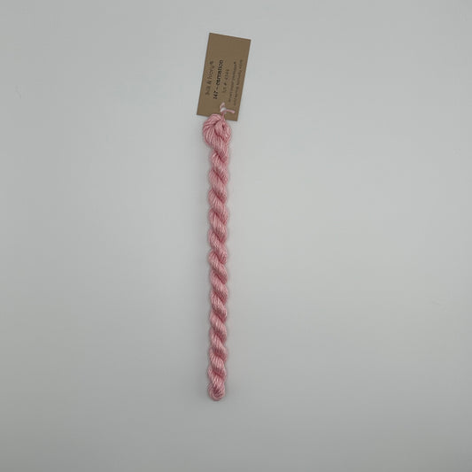 30 yard skein of silk & Ivory in the color 147 Carnation with brown tag laying flat on white background