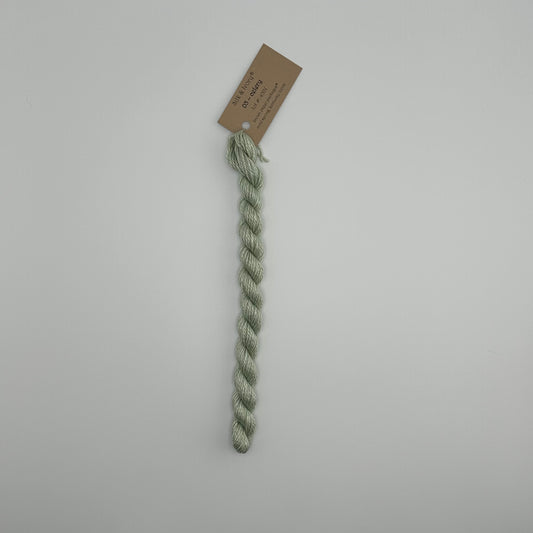 30 yard skein of silk & Ivory in the color 03 Celery with brown tag laying flat on white background