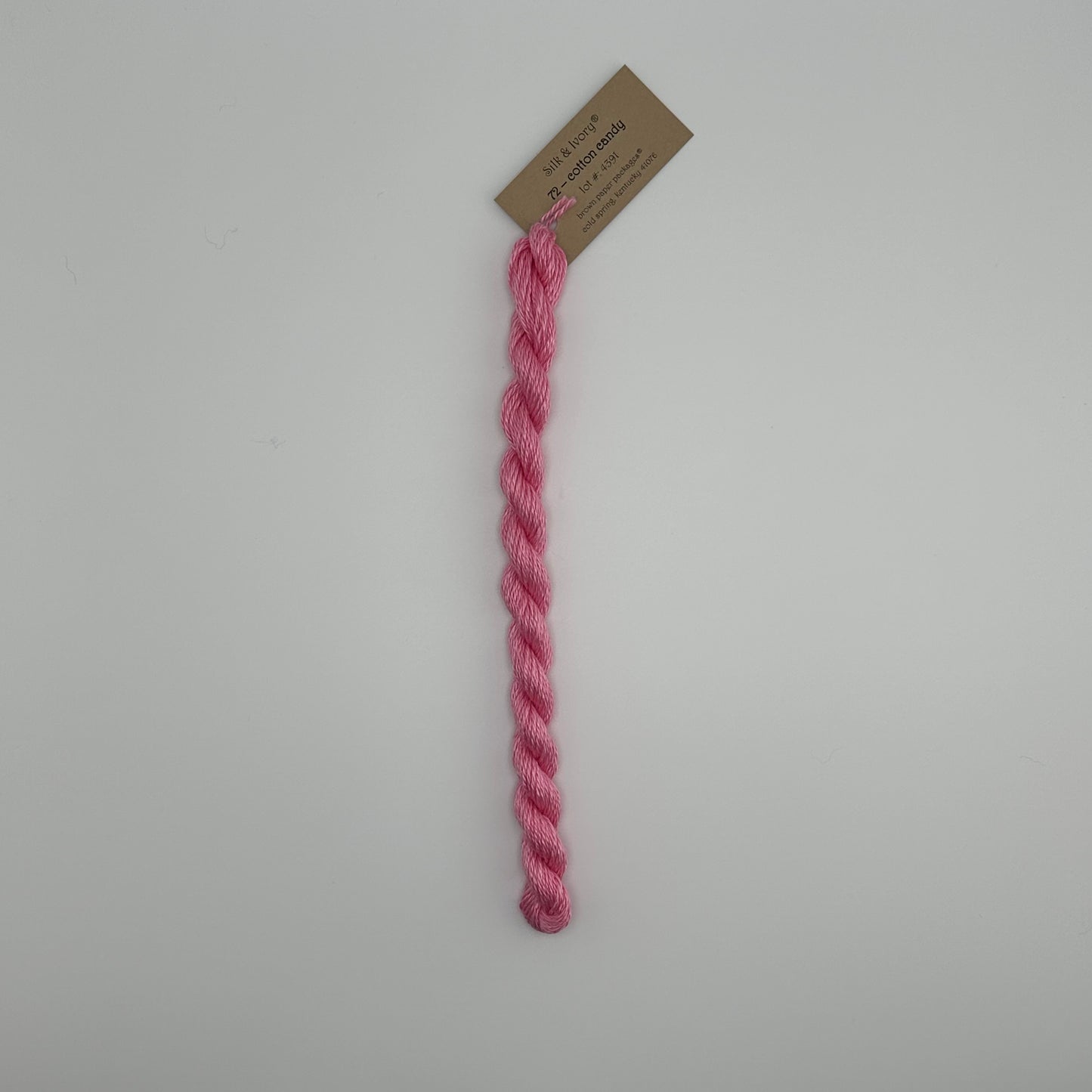 30 yard skein of silk & Ivory in the color 72 Cotton Candy with brown tag laying flat on white background