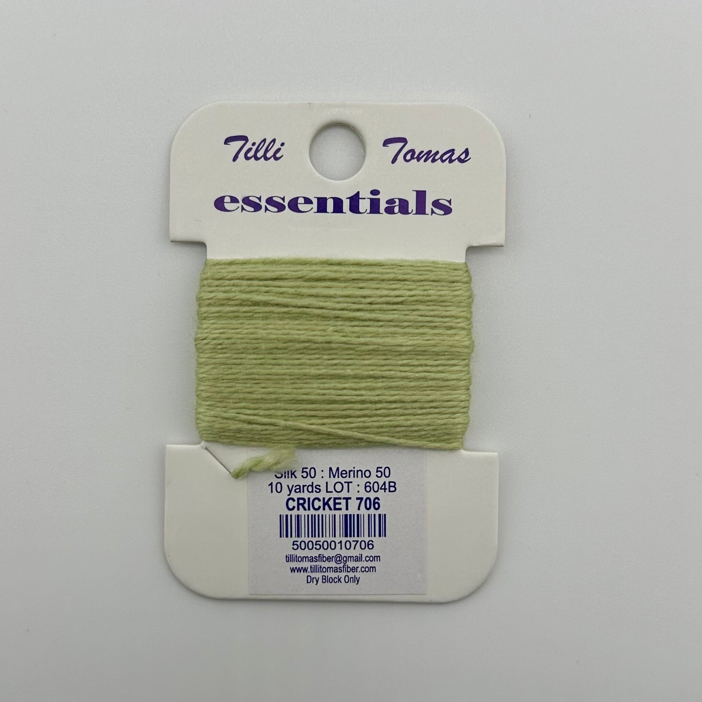 Tilli Tomas Essentials needlepoint thread, in light green cricket 706.  50% silk, 50% merino wool, 10 yards wound on a white cardboard card.