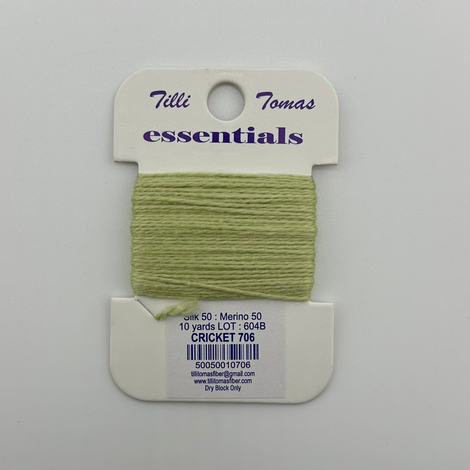 Tilli Tomas Essentials needlepoint thread, in light green cricket 706.  50% silk, 50% merino wool, 10 yards wound on a white cardboard card.
