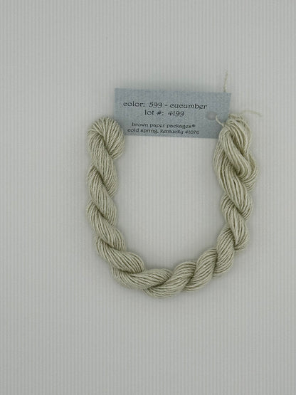 30 yard skein of Stardust Silk and Ivory needlepoint thread in Cucumber 599, with light blue label lying flat on white background