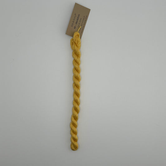 30 yard skein of silk & Ivory in the color 88 Dandelion with brown tag laying flat on white background