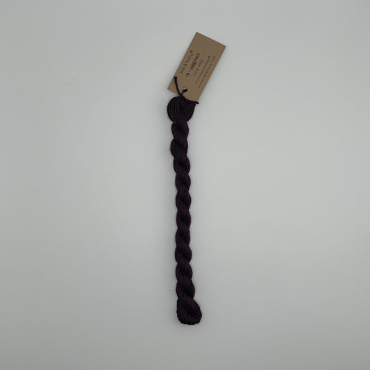 30 yard skein of silk & Ivory in the color 19 Eggplant with brown tag laying flat on white background