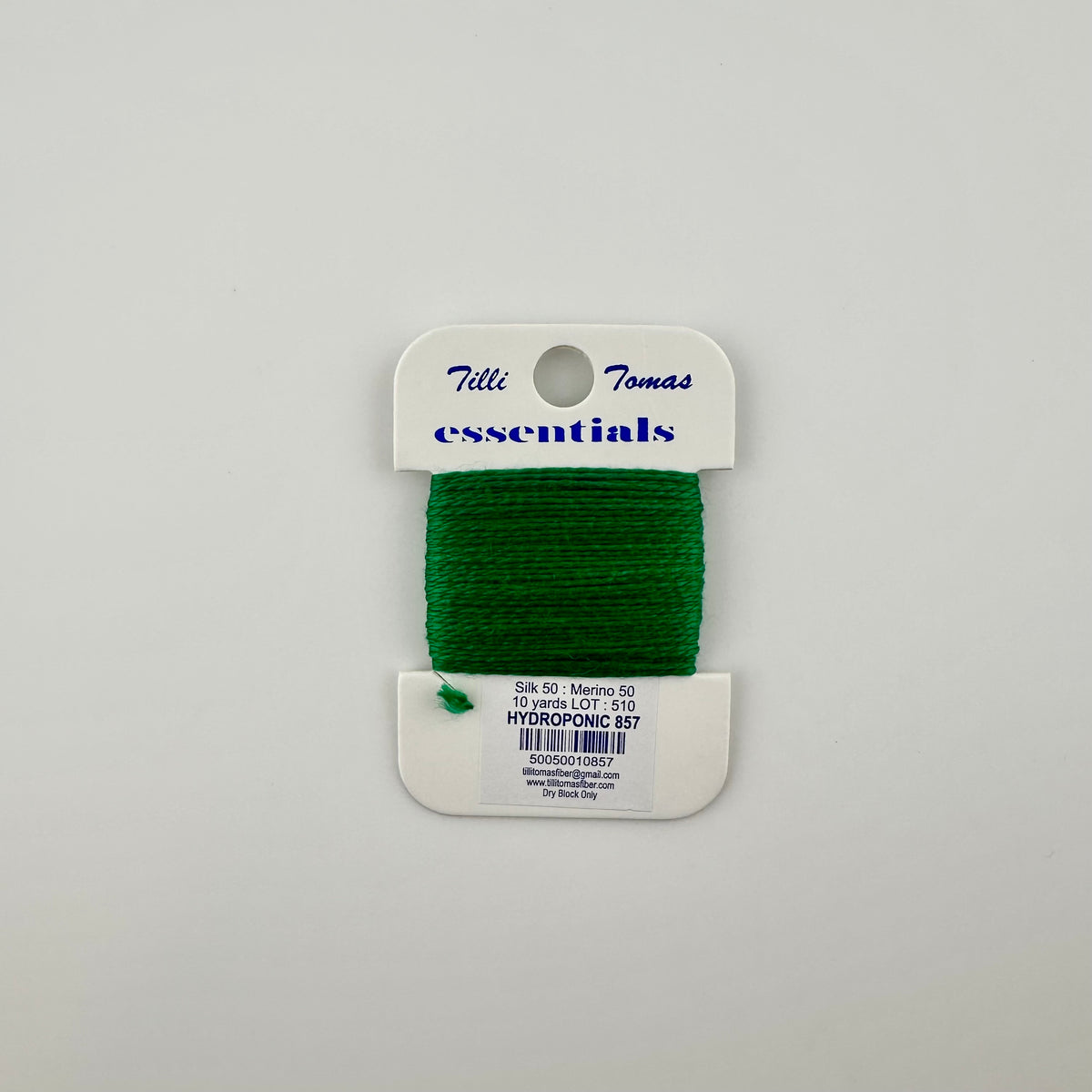 Tilli Tomas Essentials needlepoint thread, color hydroponic 857 green— 50% silk, 50% merino wool, 10 yards wound on a white cardboard card.