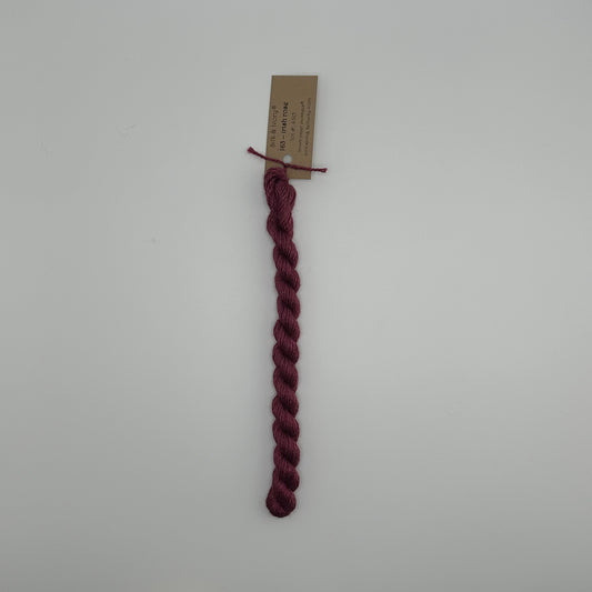 30 yard skein of silk & Ivory in the color 163 Irish Rose with brown tag laying flat on white background